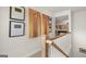 Bright hallway featuring white walls, natural wood railing, and game-themed art pieces at 600 Parnassus Rd, Locust Grove, GA 30248