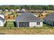 Rear exterior showcasing a screened porch, well-kept lawn, and a black iron fence, set against a backdrop of community amenities at 600 Parnassus Rd, Locust Grove, GA 30248