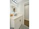 An updated bathroom with a white vanity, marble countertop, and illuminated mirror at 2594 Cavalier Dr, Decatur, GA 30034