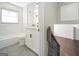 Bathroom featuring marble tile, a sink with vanity, and a tub with shower as seen from the stairway landing at 2594 Cavalier Dr, Decatur, GA 30034