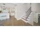 A foyer with stairs leading to kitchen area with decorative lighting, white cabinets, and hardwood floors at 2594 Cavalier Dr, Decatur, GA 30034