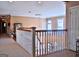 Hallway with white railings, neutral carpet, and arched window providing natural light at 219 Eagles Landing Way, Mcdonough, GA 30253