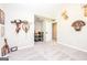 Room over garage featuring neutral carpeting with a door leading to an unfinished storage area at 305 Beavers Rd, Grantville, GA 30220