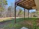 View from underneath wooden deck showing supports and grassy yard with trees at 195 Brighton Dr, Covington, GA 30016