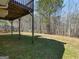 View of grass backyard with shade from deck above and wooded property line at 195 Brighton Dr, Covington, GA 30016