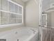 Bathroom featuring a soaking tub, window and access to the Primary bedroom at 195 Brighton Dr, Covington, GA 30016