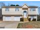 Attractive split-level home features a two-car garage, wood stairs and tidy landscaping at 195 Brighton Dr, Covington, GA 30016