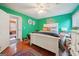 Bright bedroom with green walls, hardwood floors, white bed, and an ensuite bathroom for added convenience at 10175 Point View Dr, Jonesboro, GA 30238