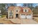 Two-story home with tan siding, brown roof, and a two-car garage at 10175 Point View Dr, Jonesboro, GA 30238