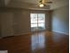 Spacious living room featuring hardwood floors, a large window and a modern ceiling fan at 97 Arnold Rd, Hampton, GA 30228