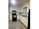 Bright kitchen with white cabinets, modern black appliances, and stylish countertops at 1700 Mccollum Rd, Sw, Conyers, GA 30094
