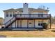 Exterior view of the back of the house with elevated deck, stairs, and yard at 231 Ashley Trace Dr, Locust Grove, GA 30248