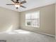 Bedroom features neutral walls, plush carpet, ceiling fan, and window with view at 231 Ashley Trace Dr, Locust Grove, GA 30248