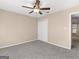 Bedroom features neutral walls, plush carpet, ceiling fan, closet, and doorway to bath at 231 Ashley Trace Dr, Locust Grove, GA 30248