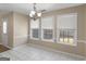 Well-lit dining room featuring tile flooring, chandelier, and natural light from three windows at 231 Ashley Trace Dr, Locust Grove, GA 30248
