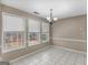 Bright dining room with tile flooring, decorative chandelier, and three large windows at 231 Ashley Trace Dr, Locust Grove, GA 30248