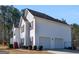 Exterior view of the home showcasing an attached two car garage and manicured landscaping at 231 Ashley Trace Dr, Locust Grove, GA 30248