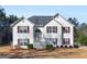 Two story home featuring classic white siding and red shutters with a lawn and mature trees at 231 Ashley Trace Dr, Locust Grove, GA 30248