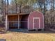 A rustic storage shed sits on the expansive lawn, adding character and practicality at 231 Ashley Trace Dr, Locust Grove, GA 30248