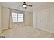 Bedroom with neutral carpet, a ceiling fan, a window with curtains, and closet doors at 245 Highview Trce, Fayetteville, GA 30215