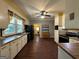 Spacious eat-in kitchen features wood floors, white cabinets, and natural light from the window over the sink at 3 Elm St, Porterdale, GA 30014