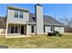 View of backyard featuring a grey siding home with black roof and a manicured lawn at 1029 Hines Rd, Moreland, GA 30259