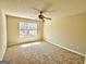 Neutral bedroom featuring a ceiling fan, carpet, and natural light from the window at 1029 Hines Rd, Moreland, GA 30259