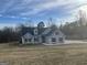 Charming home featuring gray siding, black shutters, dormer windows, and a well-maintained lawn at 1029 Hines Rd, Moreland, GA 30259