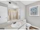 Clean bathroom with a single sink vanity, toilet, and shower/tub combo and window at 105 Jasper Dr, Stockbridge, GA 30281
