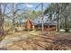 A cozy brick house sits nestled among mature trees and greenery at 105 Jasper Dr, Stockbridge, GA 30281