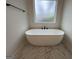 Bathroom with a freestanding soaking tub, modern fixtures, and marble-look tile flooring at 349 Lowbrooke Ct # 19, Fairburn, GA 30213