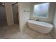 Bathroom featuring a freestanding tub, glass-enclosed shower, and marble-look tile flooring at 349 Lowbrooke Ct # 19, Fairburn, GA 30213