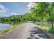 Long paved driveway with a view of the lake and lush greenery on either side at 127 Hamby Ln, Social Circle, GA 30025