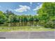 View of a calm lake surrounded by trees and greenery with a partly cloudy sky at 127 Hamby Ln, Social Circle, GA 30025