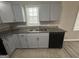 The kitchen features gray cabinets, granite countertops, and a stainless steel sink underneath a window at 1457 Richland Sw Rd, Atlanta, GA 30310