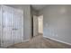 Neutral bedroom featuring carpet and double door closet, plus access to additional room at 976 Buckhorn Bnd, Locust Grove, GA 30248