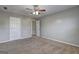 Bedroom with ceiling fan, plush carpeting, and doorways providing multiple entry options at 976 Buckhorn Bnd, Locust Grove, GA 30248