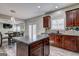 This is a kitchen with dark wood cabinets, black countertops, and stainless steel appliances at 976 Buckhorn Bnd, Locust Grove, GA 30248