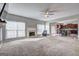 Expansive living area with fireplace flowing into kitchen with lots of natural light and ceiling fan at 976 Buckhorn Bnd, Locust Grove, GA 30248