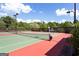 Well-maintained tennis court featuring benches and professional net with trees in the background at 976 Buckhorn Bnd, Locust Grove, GA 30248