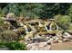 A rock water feature cascades beautifully among lush greenery at 976 Buckhorn Bnd, Locust Grove, GA 30248