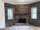 Cozy stone fireplace with a wooden mantel and windows on either side at 232 Darwish Dr, Mcdonough, GA 30252