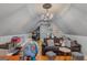 Spacious attic featuring hardwood floors, a brown sofa, a quirky chandelier, and ample natural light at 417 Harper Rd, Mcdonough, GA 30252