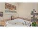 Bright bathroom features a corner bathtub with tile surround, decorative accents, and a stylish faucet at 417 Harper Rd, Mcdonough, GA 30252