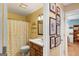 Yellow-walled bathroom featuring a shower/tub combo, vanity, and framed photos on the adjacent hallway wall at 417 Harper Rd, Mcdonough, GA 30252