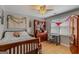 Bright bedroom with ceiling fan, light hardwood floors, a world map, and a large window at 417 Harper Rd, Mcdonough, GA 30252