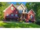 Charming two-story red brick home with a beautifully landscaped front yard and mature plantings at 417 Harper Rd, Mcdonough, GA 30252