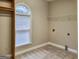 Bright laundry room with a window, tile floor, and plenty of space for appliances and storage solutions at 417 Harper Rd, Mcdonough, GA 30252