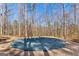 A covered pool with a wooden deck in the backyard of a home surrounded by trees at 417 Harper Rd, Mcdonough, GA 30252