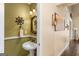 Stylish powder room with a pedestal sink, ornate mirror, and decorative lighting, perfect for guests at 417 Harper Rd, Mcdonough, GA 30252